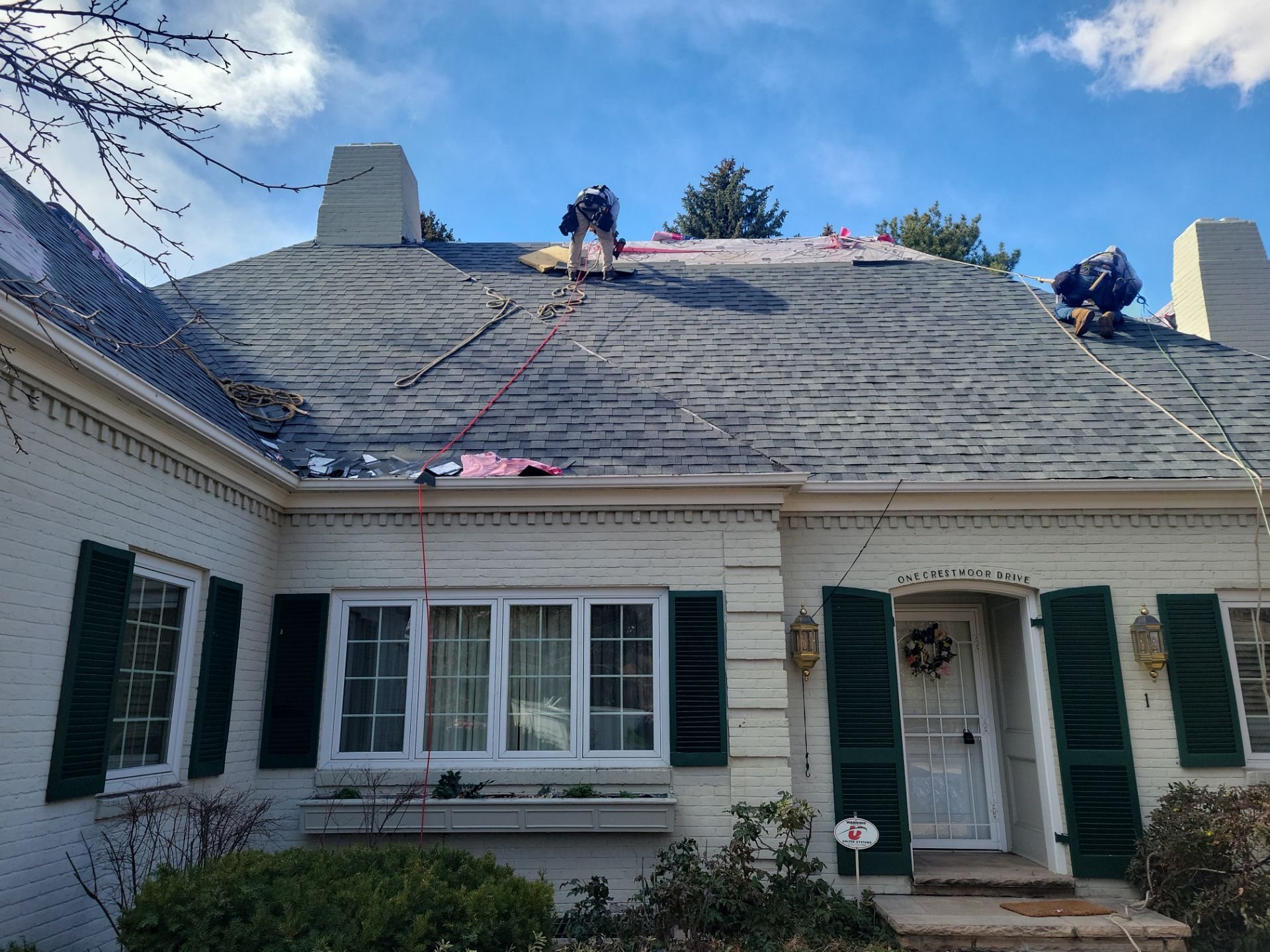 Excel Roofing roofers replacing an asphalt shingle roof on a one story home
