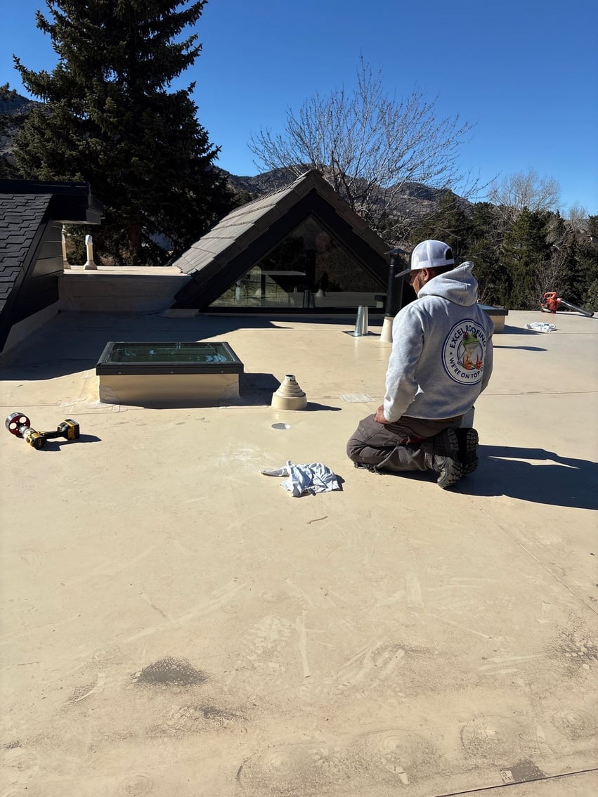 Excel Roofing Flat Roof expert repair technician examining a TPO roof
