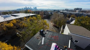 Excel Roofing contractor replacing a multifamily roof with the denver skyline in the background