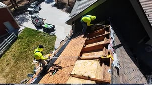 Expert Excel Roofing repair technicians work on a roof with improper attic ventilation 