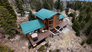a beautiful colorado mountain home with a brand new green standing seam metal roof