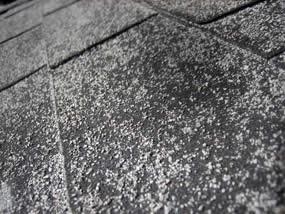 hail damaged asphalt shingle roof with granule loss on the shingles