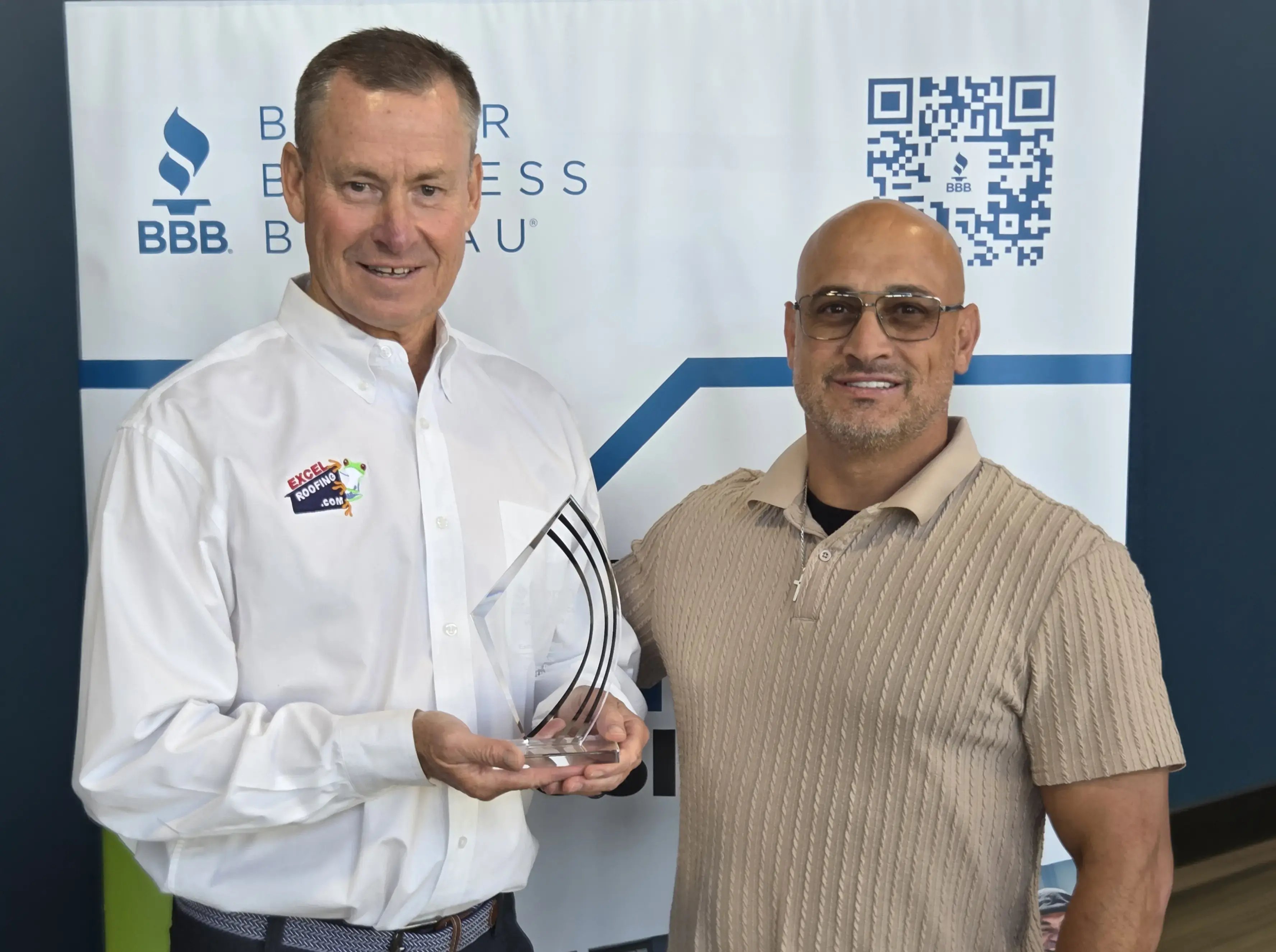 J Bretz and Dominic Herrera with Excel Roofing's BBB Torch award for ethics 2026