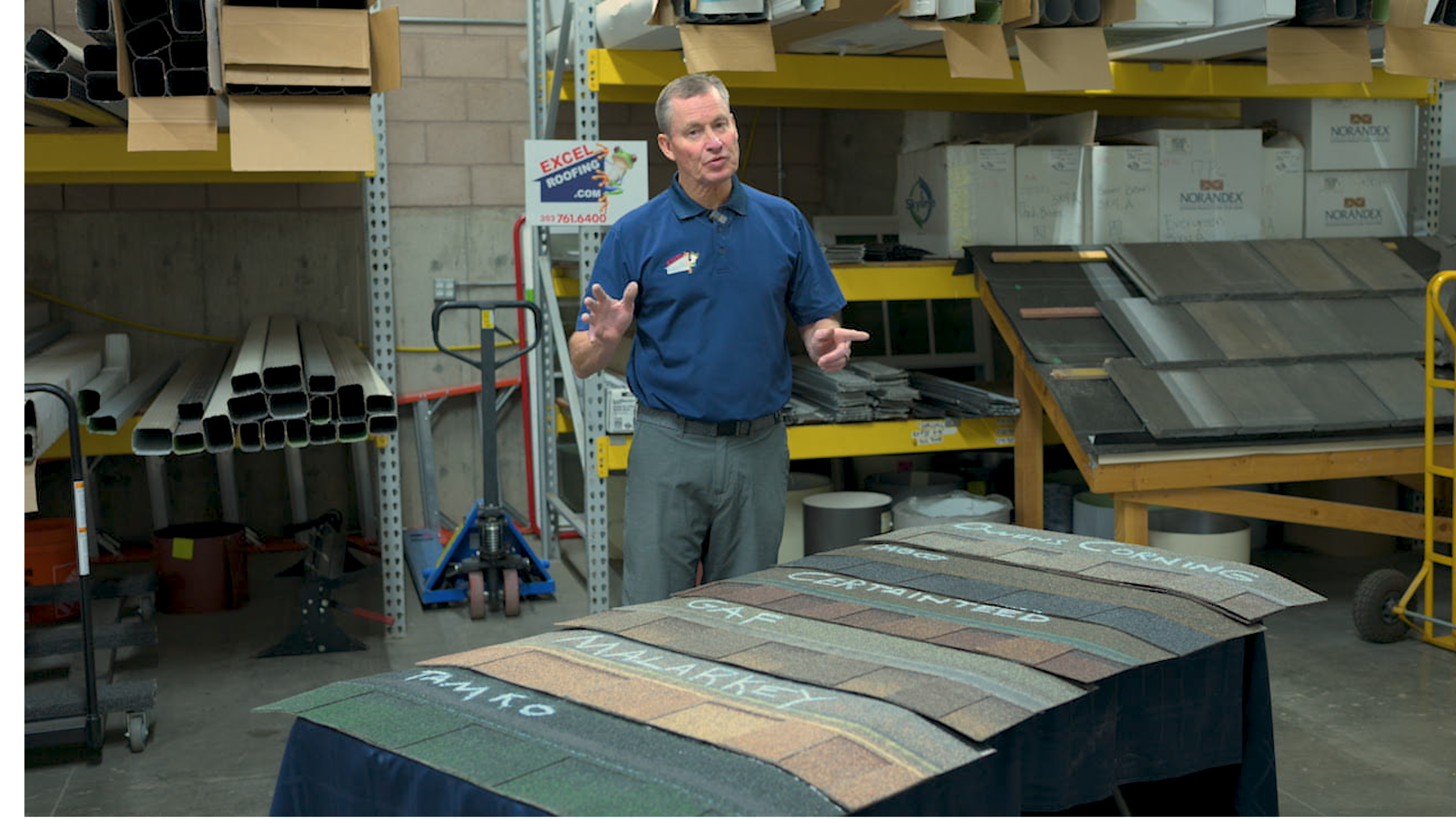J Bretz in a workshop with 6 different asphalt shingle manufacturer's shingles ready for his review