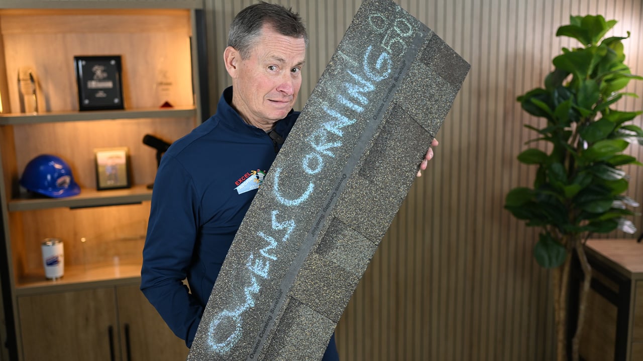 J Bretz holding an Owens Corning class 4 shingle in the Excel Roofing studio