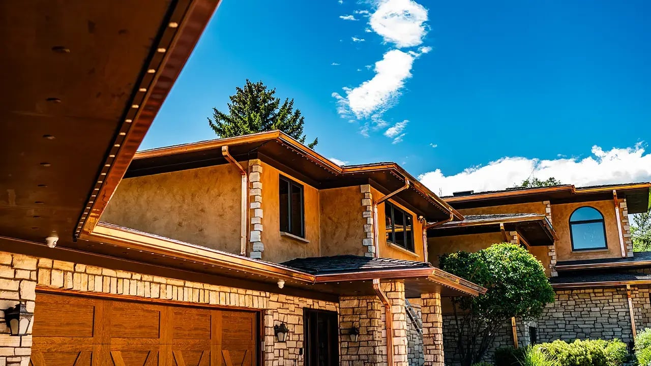 multi story home with copper gutters recently installed, the coper is bright and shiny 