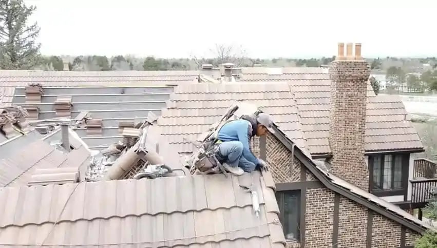 A Excel Roofing roofer replacing class 4 tile on a roof