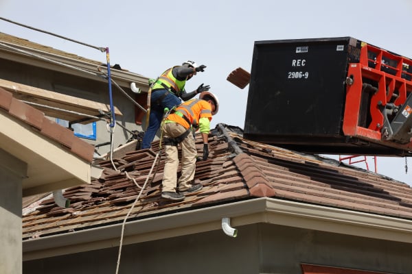 Tile roof replacement in Superior Colorado with roofing crew removing tiles