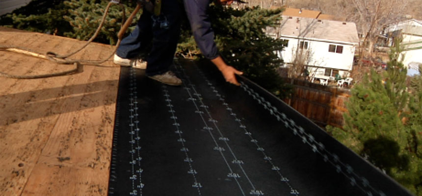 Roofer installing heat cable on a roof