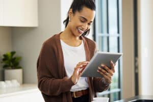 Woman Looking at ipad considering roofing services in Highlands Ranch, CO